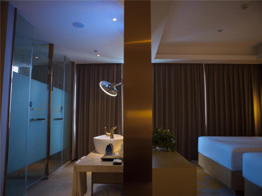 齐齐哈尔Lavande Hotel Qiqihar Supervisory Office的一间卧室配有一张床和一张带台灯的桌子