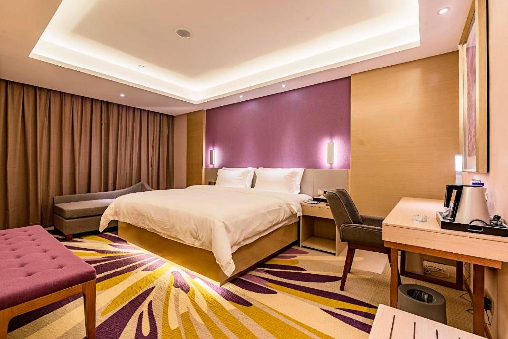 秦皇岛Lavande Hotel (Qinhuangdao Yingbin Road Railway Station Branch)的配有一张床和一张书桌的酒店客房