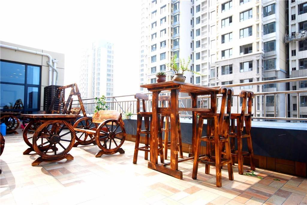 日照Lavande Hotel Rizhao Rong'an Square Wanda Movie Theater Branch的阳台上的一组木桌和椅子
