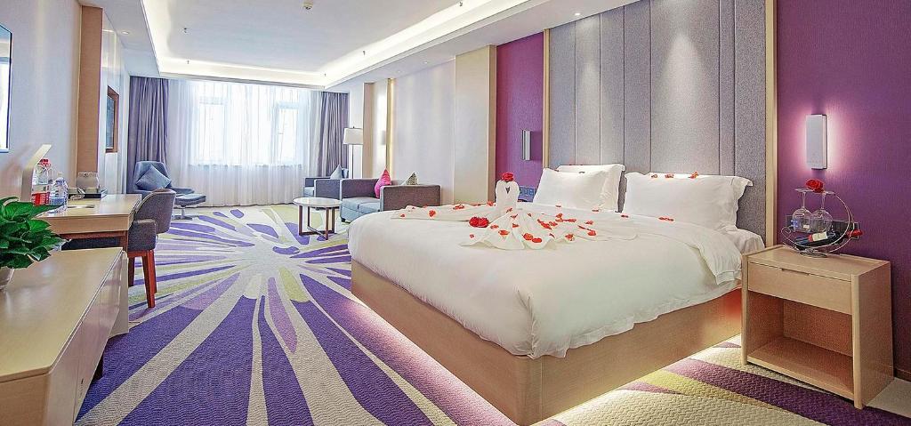 邯郸Lavande Hotel Handan Congtai Park New Century Plaza的酒店客房设有一张大床和一张书桌。