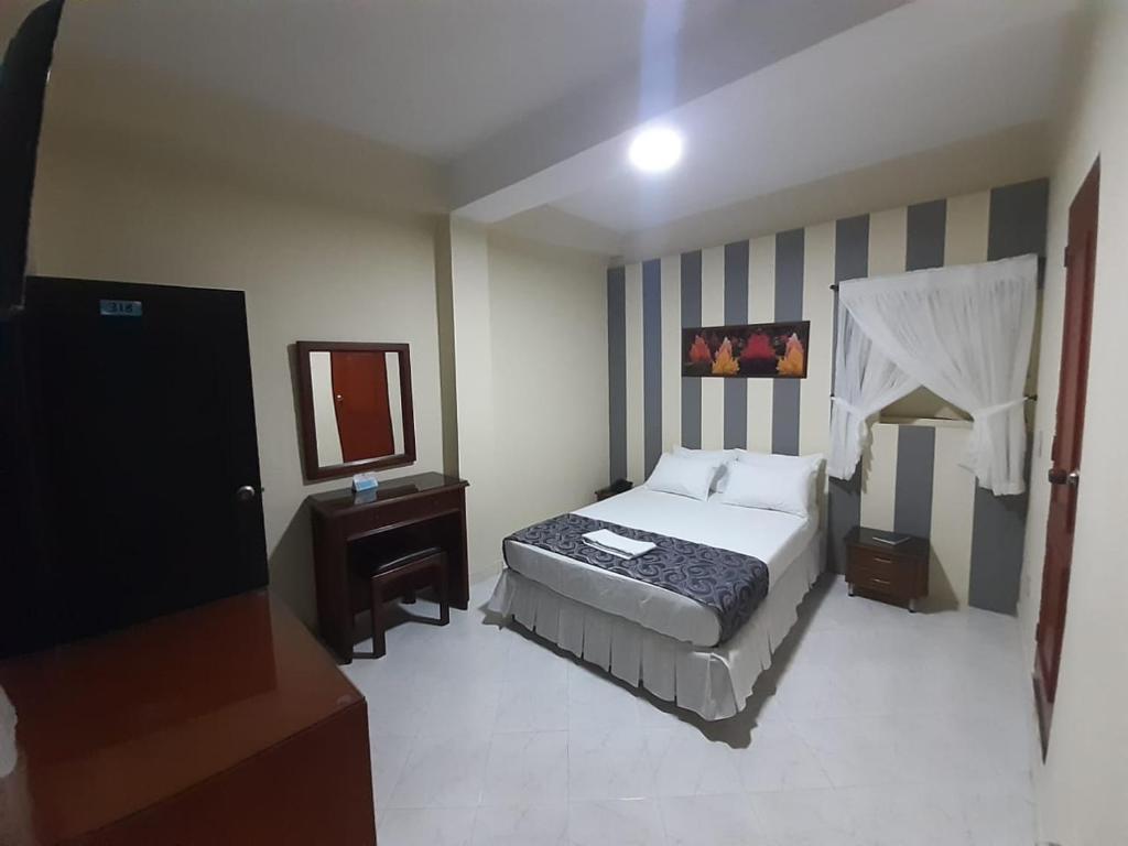 库库塔Hotel El Andino的酒店客房,配有床和镜子