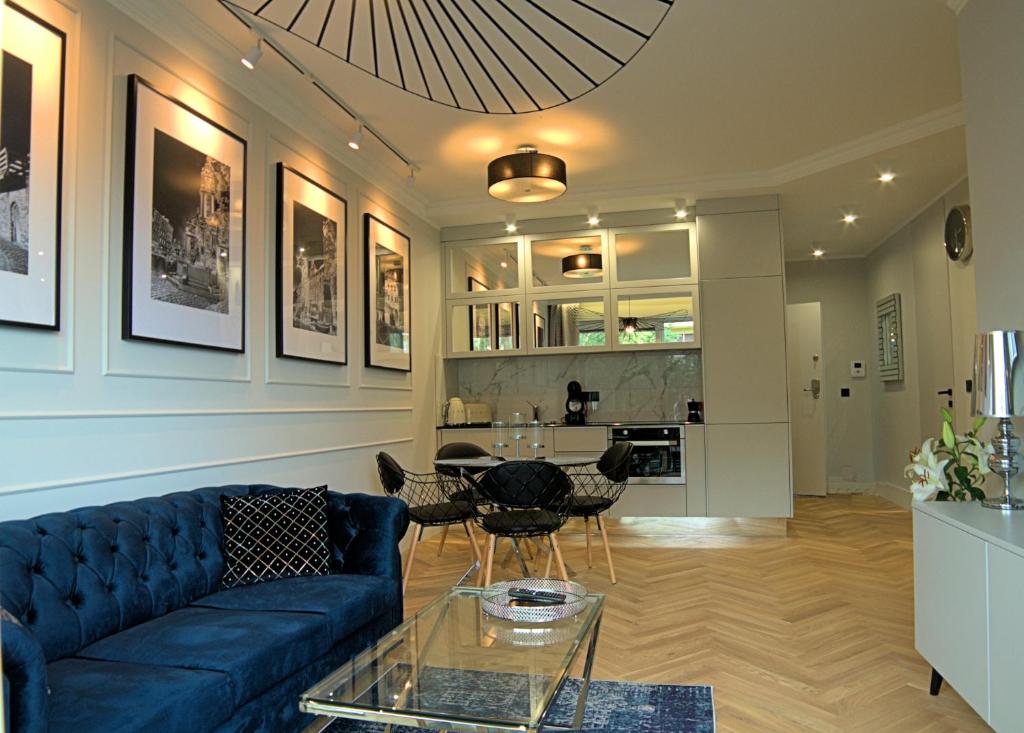 托伦Blue Velvet Premium Apartments III的客厅配有蓝色的沙发和桌子