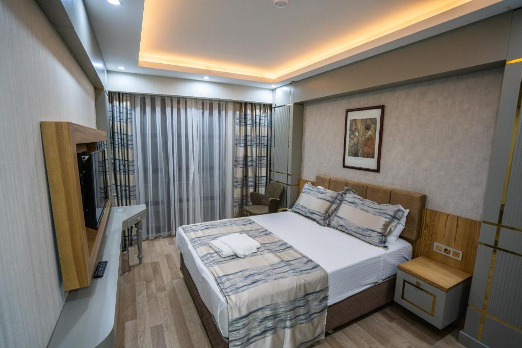 安卡拉Lion City Hotel Kizilay的一间小卧室,配有一张床和电视