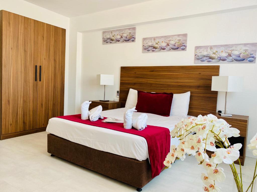 拉纳卡爱诺拉公寓酒店的一间卧室配有一张带红色毯子的大床