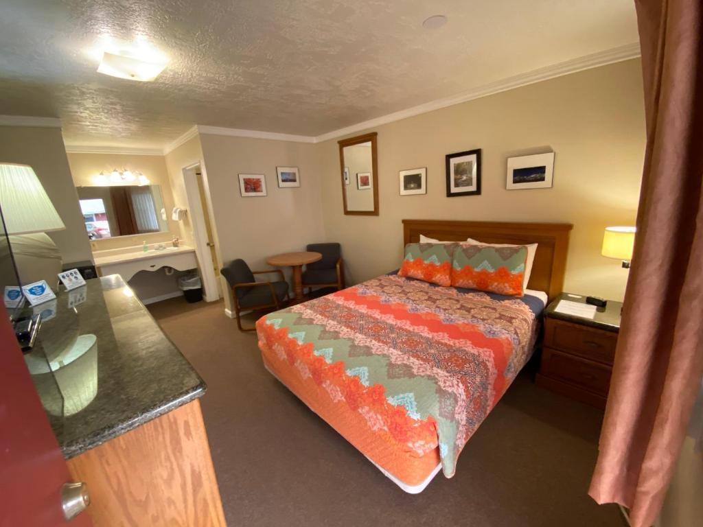 独立城Independence Courthouse Motel的酒店客房配有一张床、一张书桌和一张书桌。
