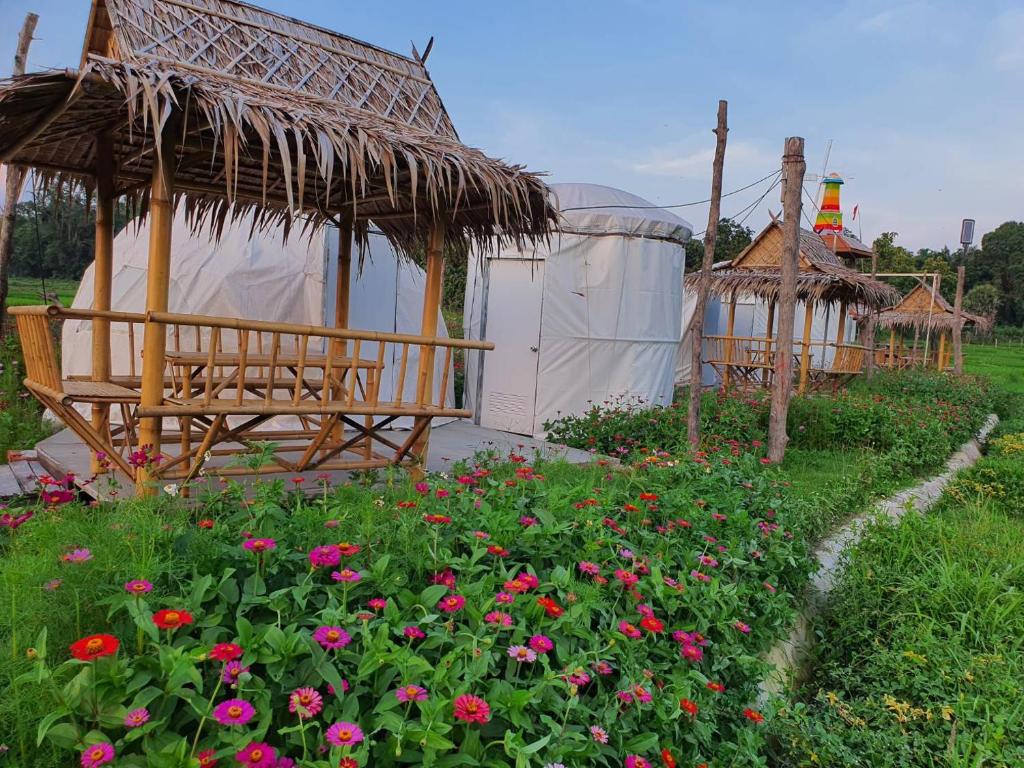 南邦Baanrimdoi Resort Lampang的草上种着凉亭和花的花园