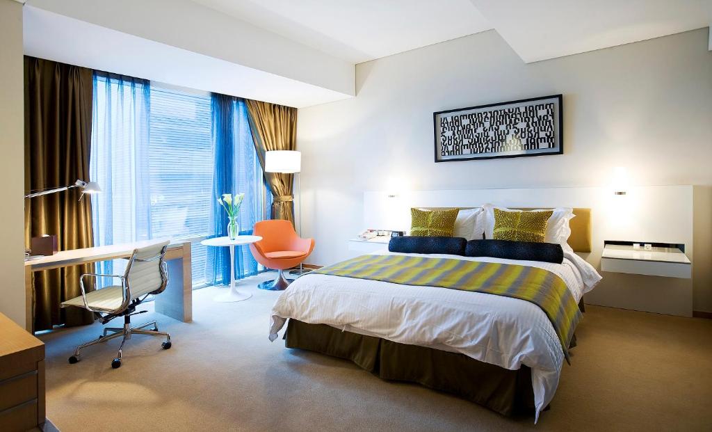 水原市水原华美达广场酒店的配有一张床和一张书桌的酒店客房