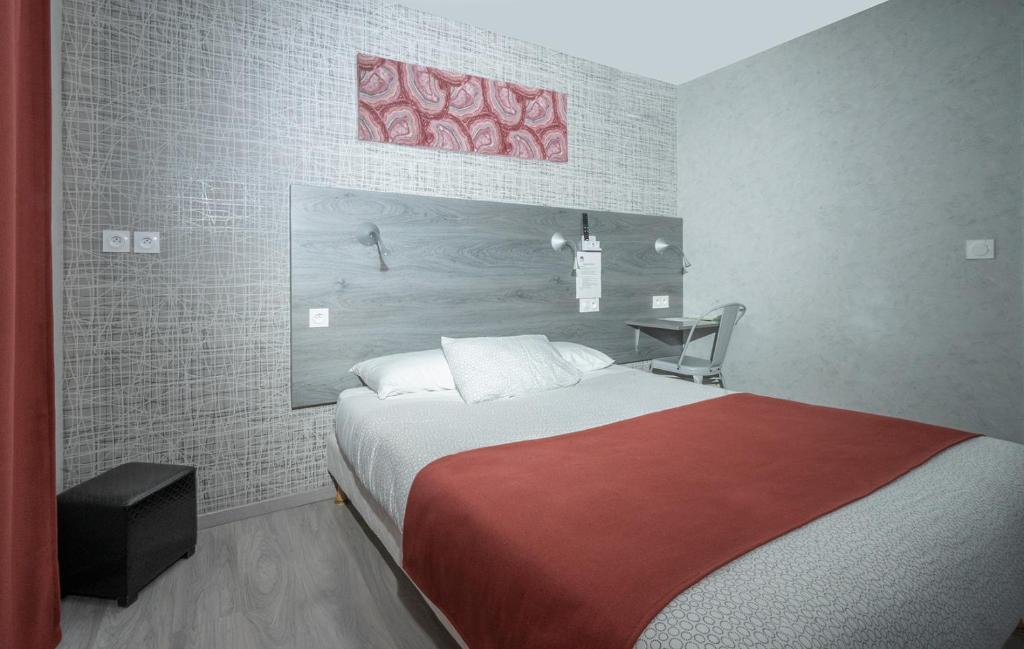 普瓦捷马克床酒店的一间卧室配有一张带红色毯子的大床