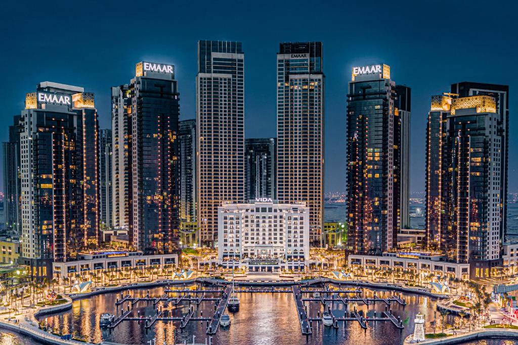 迪拜云溪港葳达酒店的一群高大的建筑在晚上在城市里