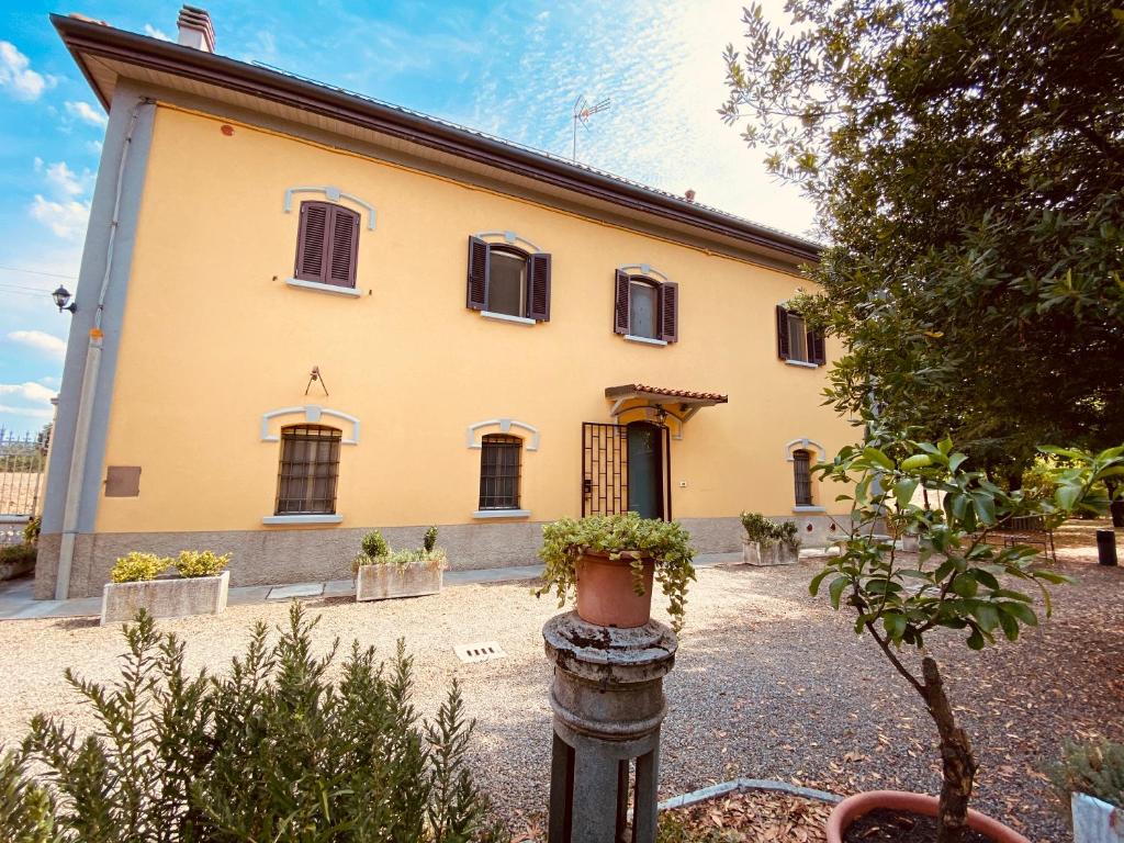 萨韦纳河畔圣拉扎罗B&B Villino Margherita的一座黄色的大建筑,前面有植物