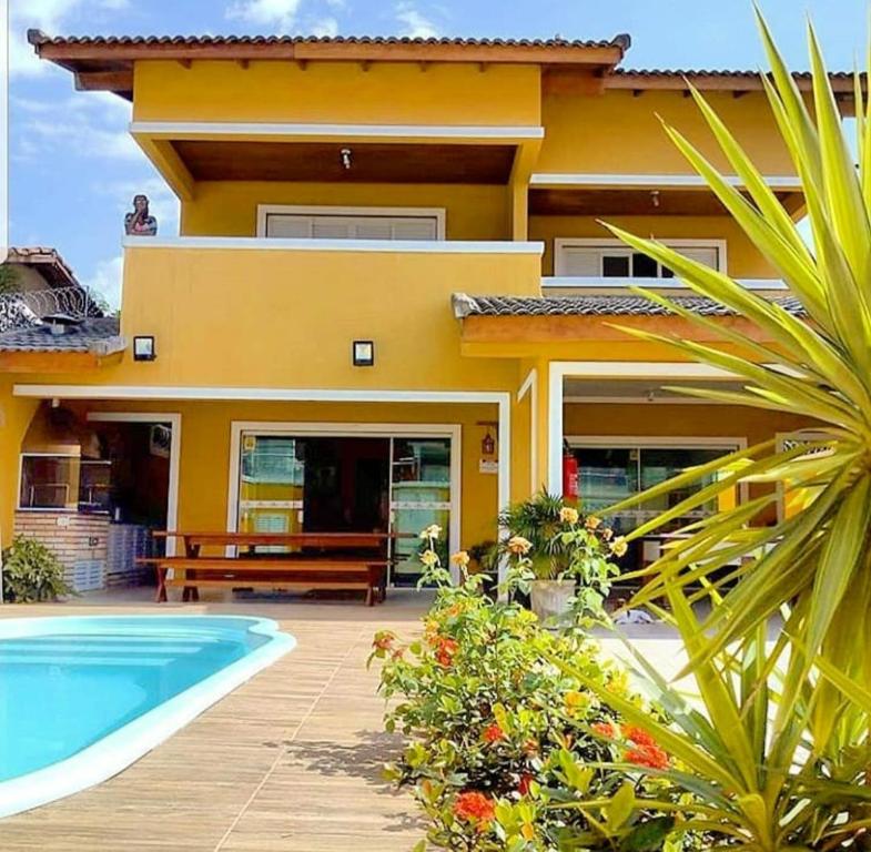 瓜鲁雅马科斯民宿的黄色的房子,前面有一个游泳池