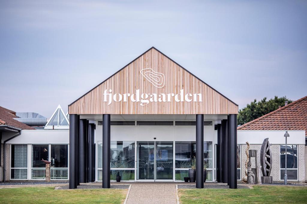 灵克宾Fjordgaarden - Kurbad - Hotel - Konference的前面有标志的建筑