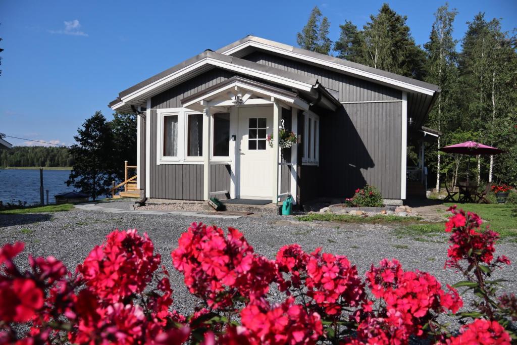 SysmäHattapukki - Villa Himpula的前面有红花的小棚子