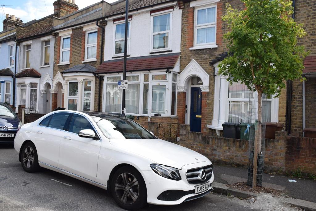 伦敦Three Bedroom House Lancaster Road的停在房子前面的白色汽车