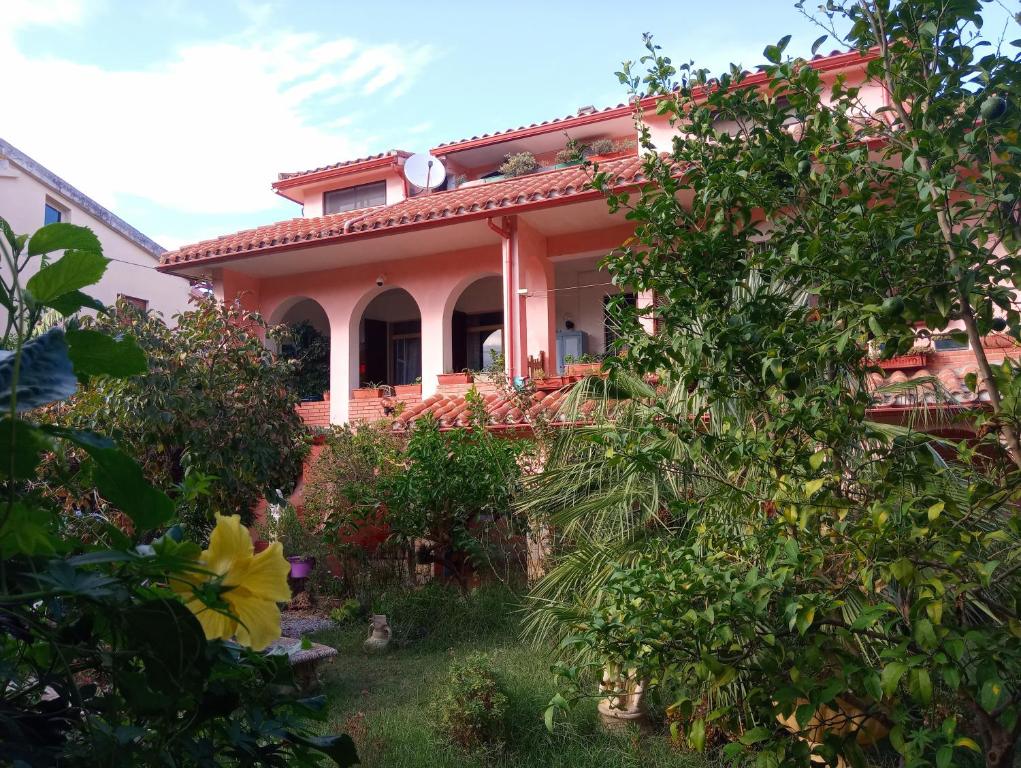 SiliquaVilla Corrias的前面有树木的粉红色房子