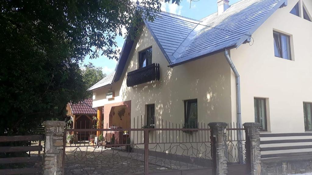 苏恰维塔Pensiunea Casa Domniței Sucevița的白色的房子,有蓝色的屋顶和栅栏