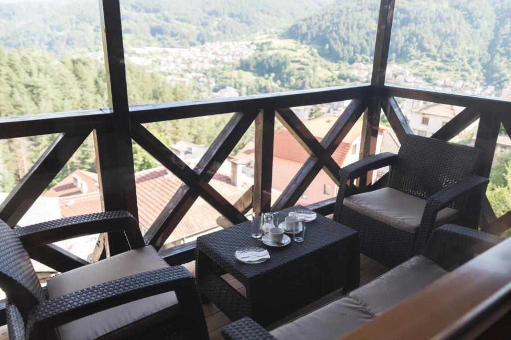 代温Planinski Polah House的阳台配有椅子和桌子及玻璃杯