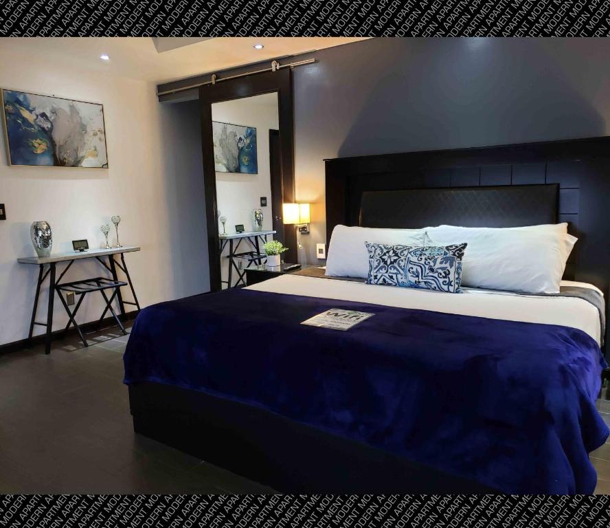 罗萨里托The Condo (by Modern Apartments)的一间卧室配有一张带蓝色毯子的大床