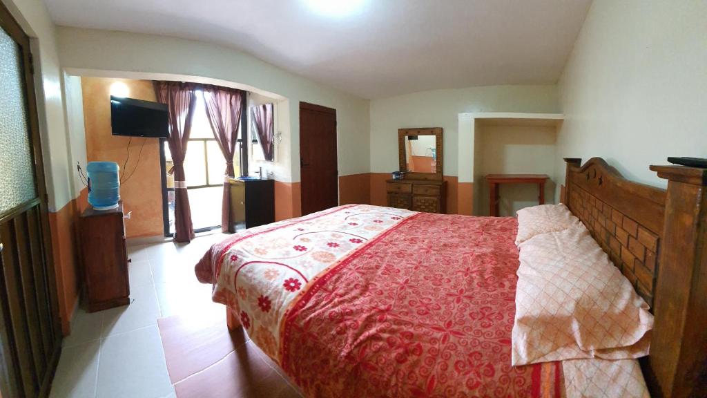 萨卡特兰Habitación sencilla en Zacatlán Centro的一间卧室配有一张大床和红色的床罩