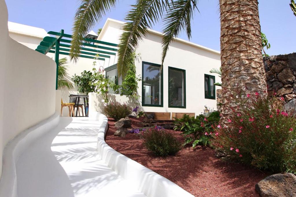科斯塔特吉塞Unique, Stylish & Calm El Estanque by the Sea, Adults Only的院子里有棕榈树的白色房子