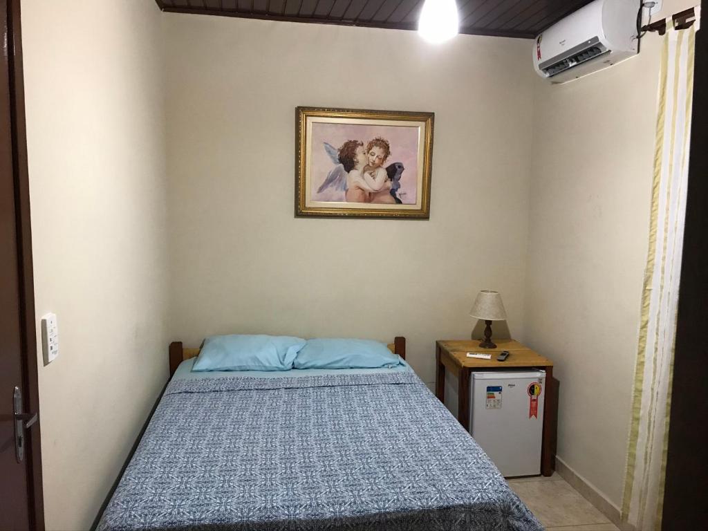 伯迪亚哥Pousada Jolly Roger的卧室配有一张床,墙上挂着一幅画