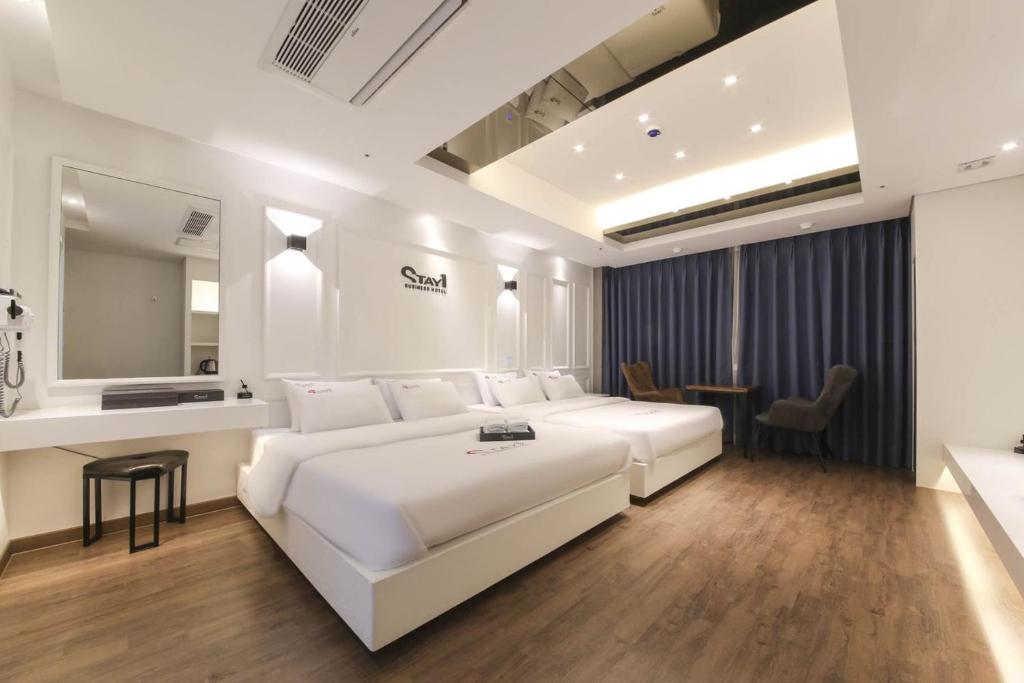 光州Stay Hotel的卧室配有一张白色大床和一张书桌