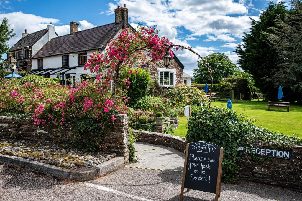 阿斯克The Greyhound Inn and Hotel的鲜花屋前的标志