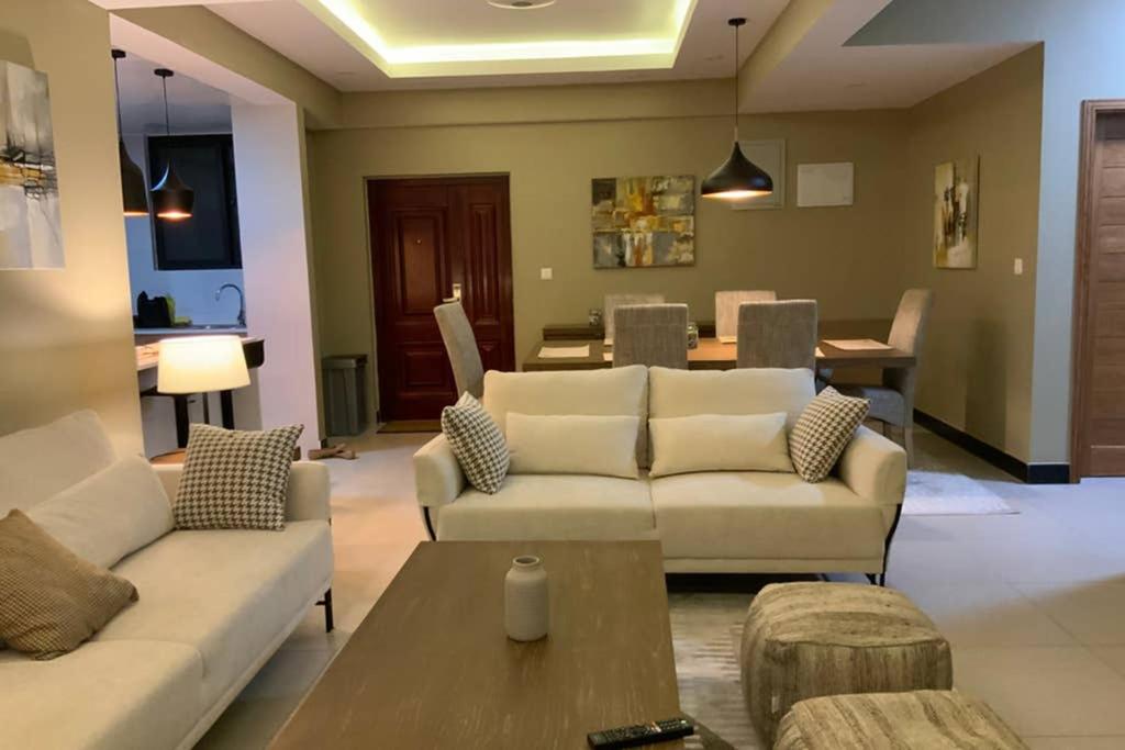 达累斯萨拉姆Grany Apartment - Palm Village的客厅配有两张沙发和一张桌子