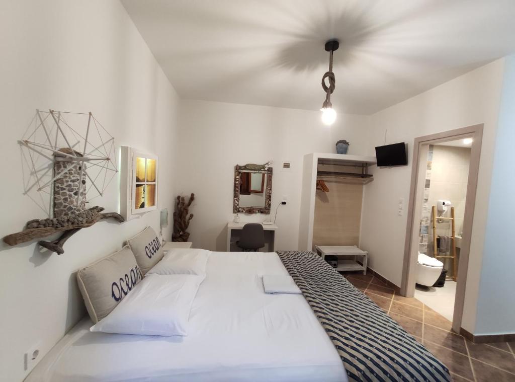 阿达玛斯麦都萨公寓的一间带白色大床的卧室和一间浴室