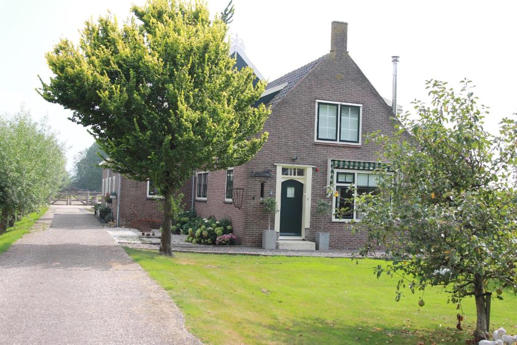 PurmerBed en Breakfast Het Friesche Paard的前面有树的砖房