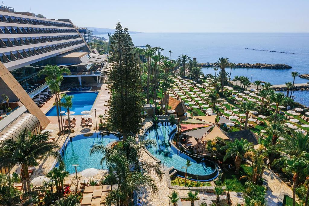 利马索尔利马索尔阿马图斯海滩酒店的享有带游泳池和海洋的度假村的空中景致