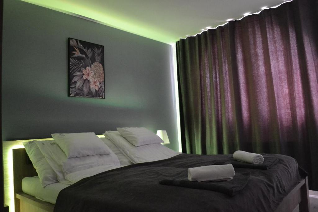 德布勒森Főnix Design Rooms的一间卧室配有一张大床和两条毛巾