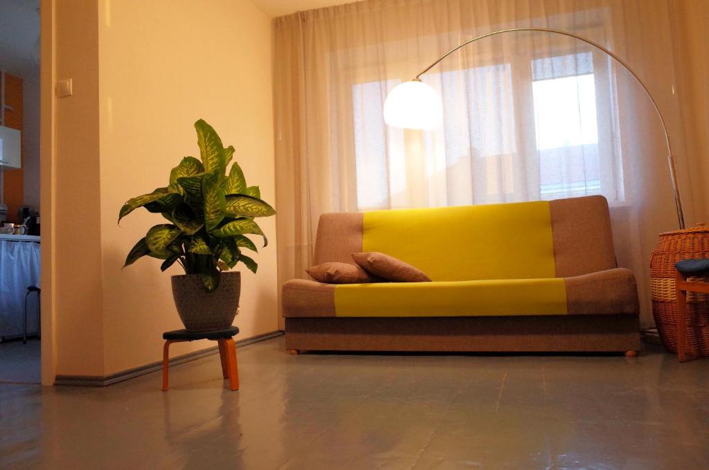瓦尔米耶拉Apartment City Heart的客厅里一张黄色的沙发,上面有盆栽植物