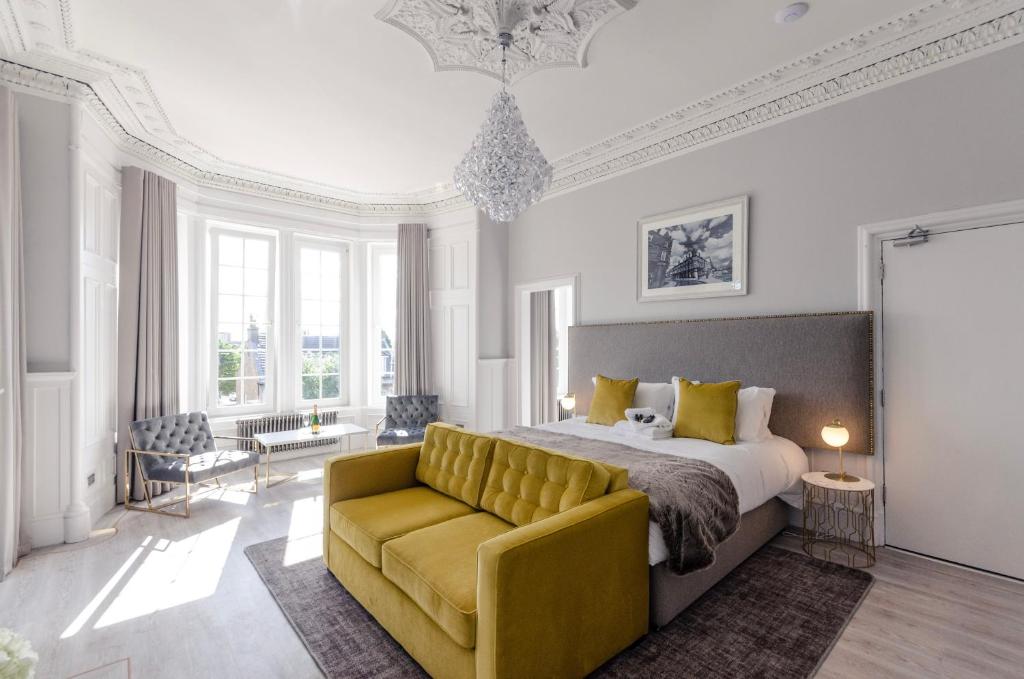 马瑟韦尔Sweeney Apartments & Rooms的一间卧室配有一张床和一张黄色的沙发