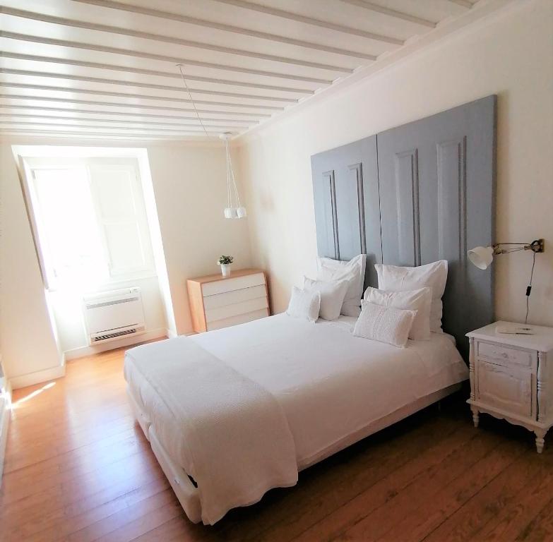 里斯本马格达莱纳酒店的卧室配有白色大床和白色枕头