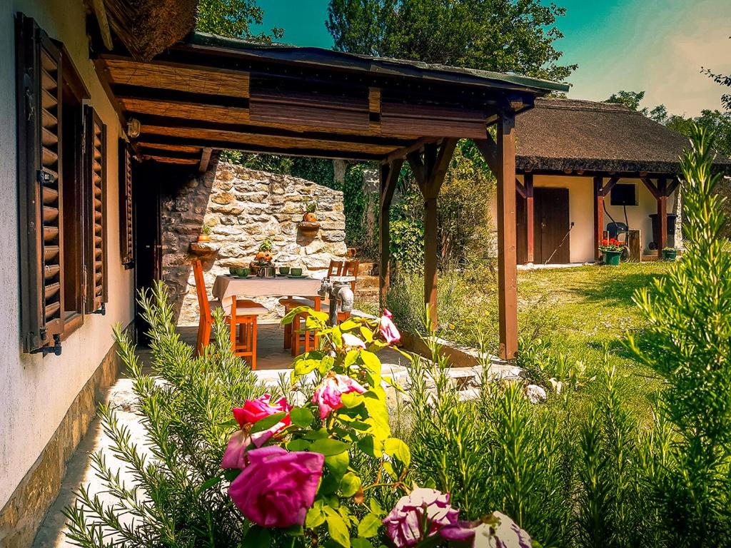 包道乔尼托毛伊Wild Boar Cottage - Romantic getaway的房屋前带桌子和鲜花的庭院