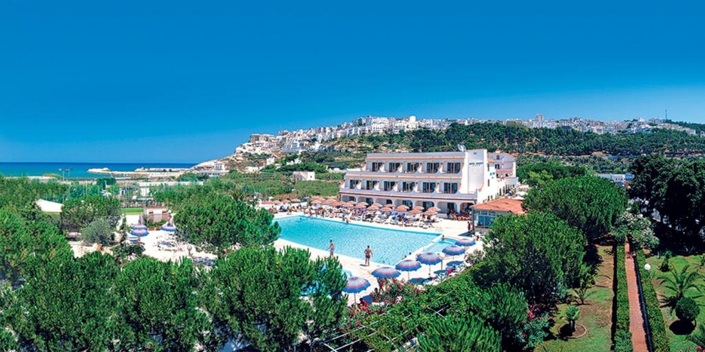 佩斯基奇Hotel D'Amato的一个带遮阳伞的大型游泳池的度假村