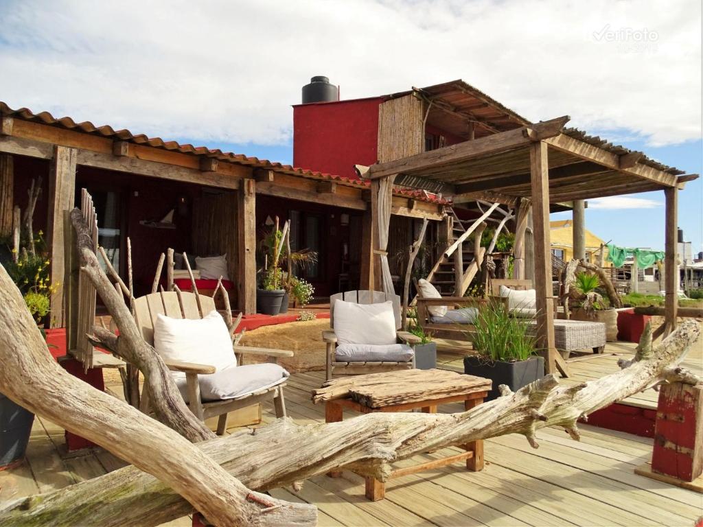 凯博波洛尼奥La Perla del Cabo的一个带椅子的木制甲板和一座房子