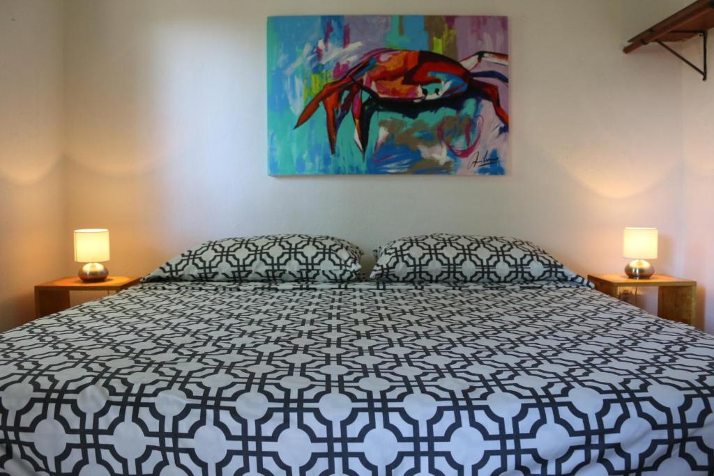 圣何塞德尔卡沃帕萨达斯诺尔马纳纳酒店的卧室配有一张床,墙上挂有绘画作品
