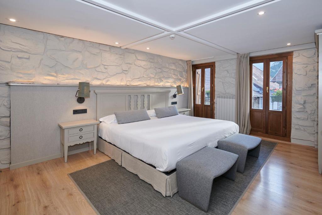伊萨瓦洛拉旅馆的一间卧室设有一张大床和石墙