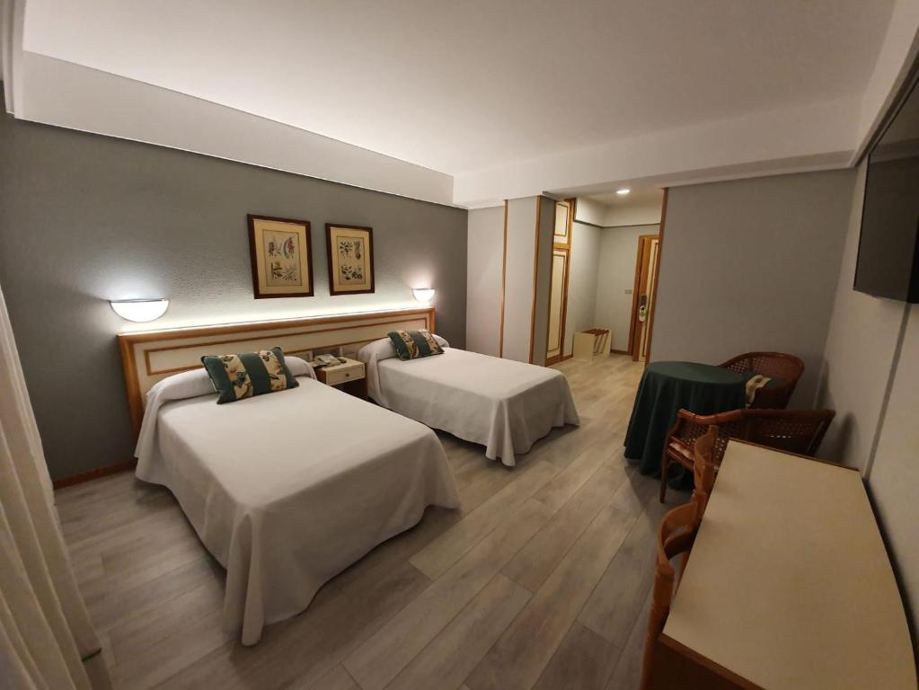 博伊罗Hotel Alda Boiro的酒店客房设有两张床和一张桌子。