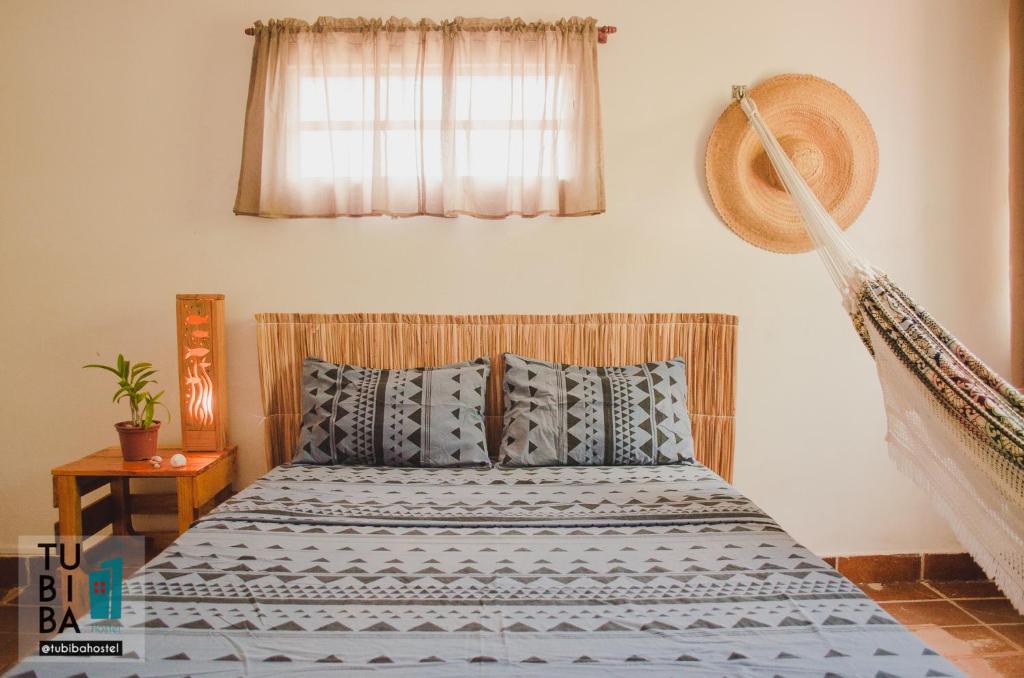 塔曼达雷Tubiba Hostel的一间卧室配有蓝色和白色床单
