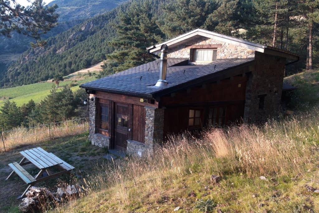 圣胡利娅-德洛里亚Casa en entorno natural , registro HUT6-00-7741的山丘上的小房子,前面有长凳
