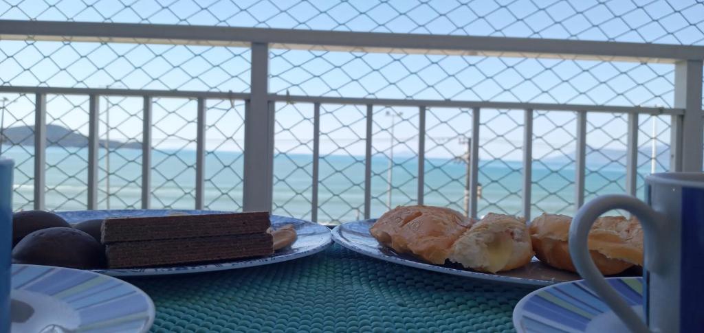 卡拉瓜塔图巴Linda Vista e Som das Ondas的一张桌子,上面放着三盘糕点和巧克力蛋糕