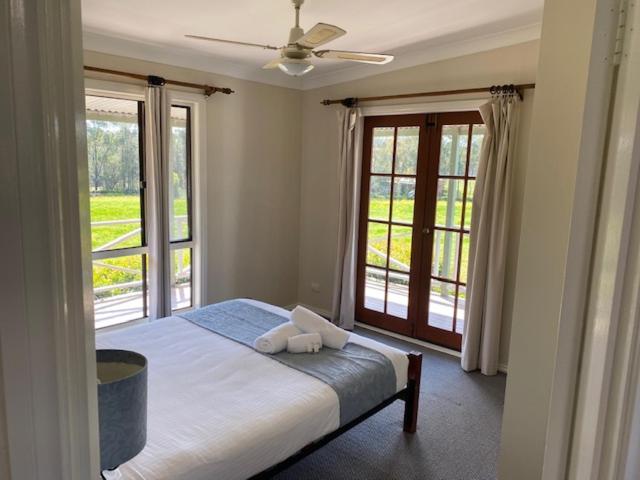 波高尔宾两棵树乡村小屋酒店的一间卧室设有一张床和一个大窗户