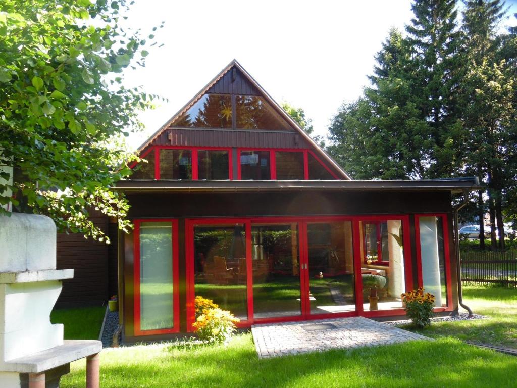 NeuhermsdorfFerienwohnung Haus Waldeck的院子里有红色门的房子