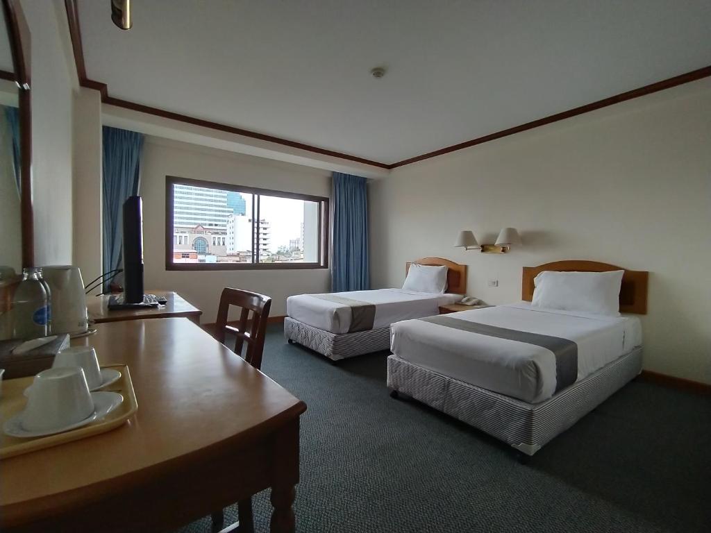 合艾斯格黄金酒店的酒店客房配有两张床和一张书桌