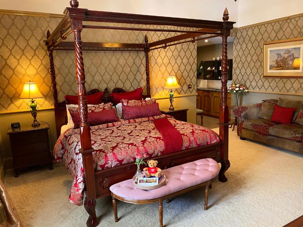 双水域布里布里河滨假日旅馆的一间卧室配有一张天蓬床,卧室的长椅上设有娃娃