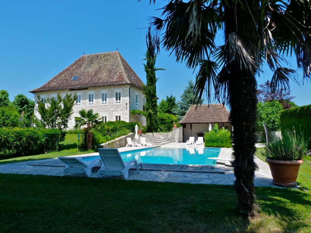 莱萨韦尼埃Domaine du Manoir的庭院前带游泳池的房子