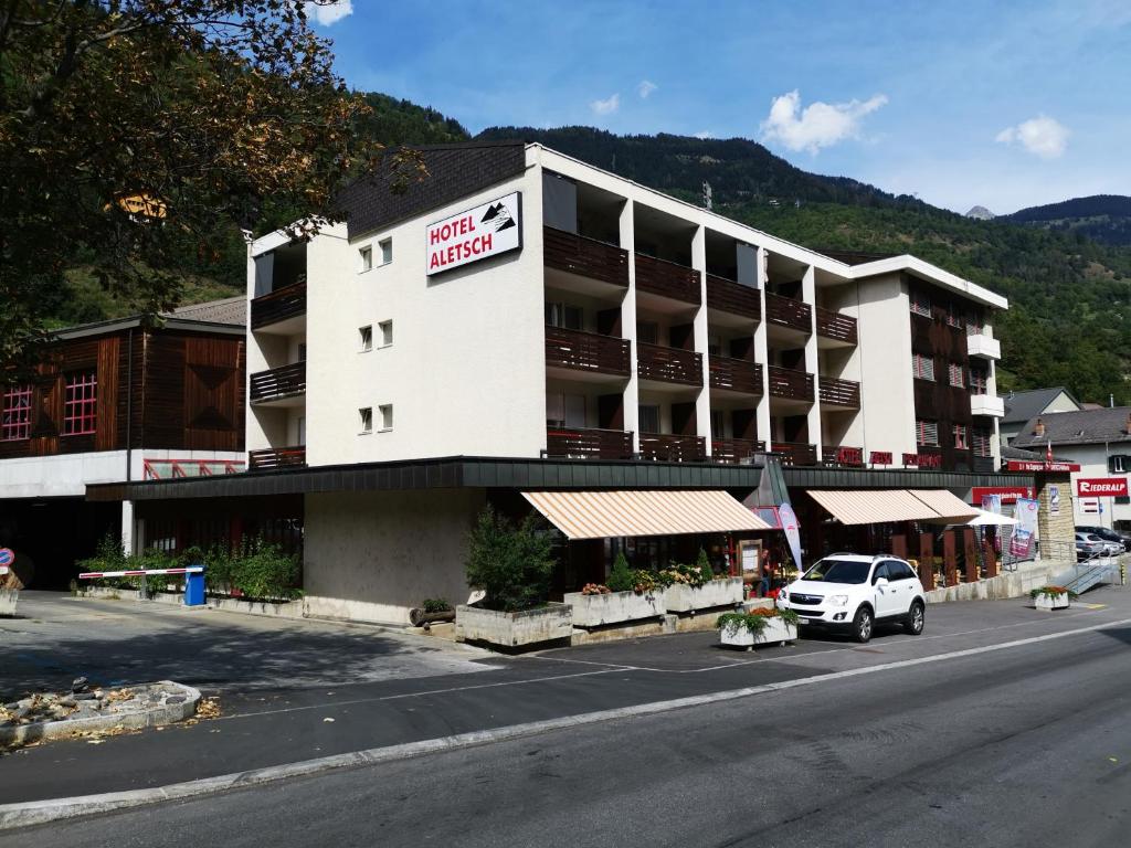 莫雷尔Hotel Restaurant Aletsch的一间白色的酒店,前面有一辆汽车